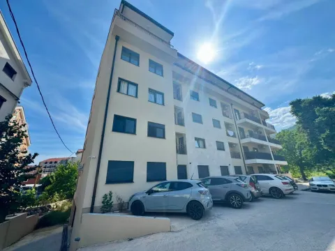 Exterior view of an apartment building with parking in front. - image 5