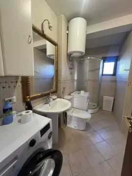 Bathroom with a shower cabin, sink, and washing machine. - image 23