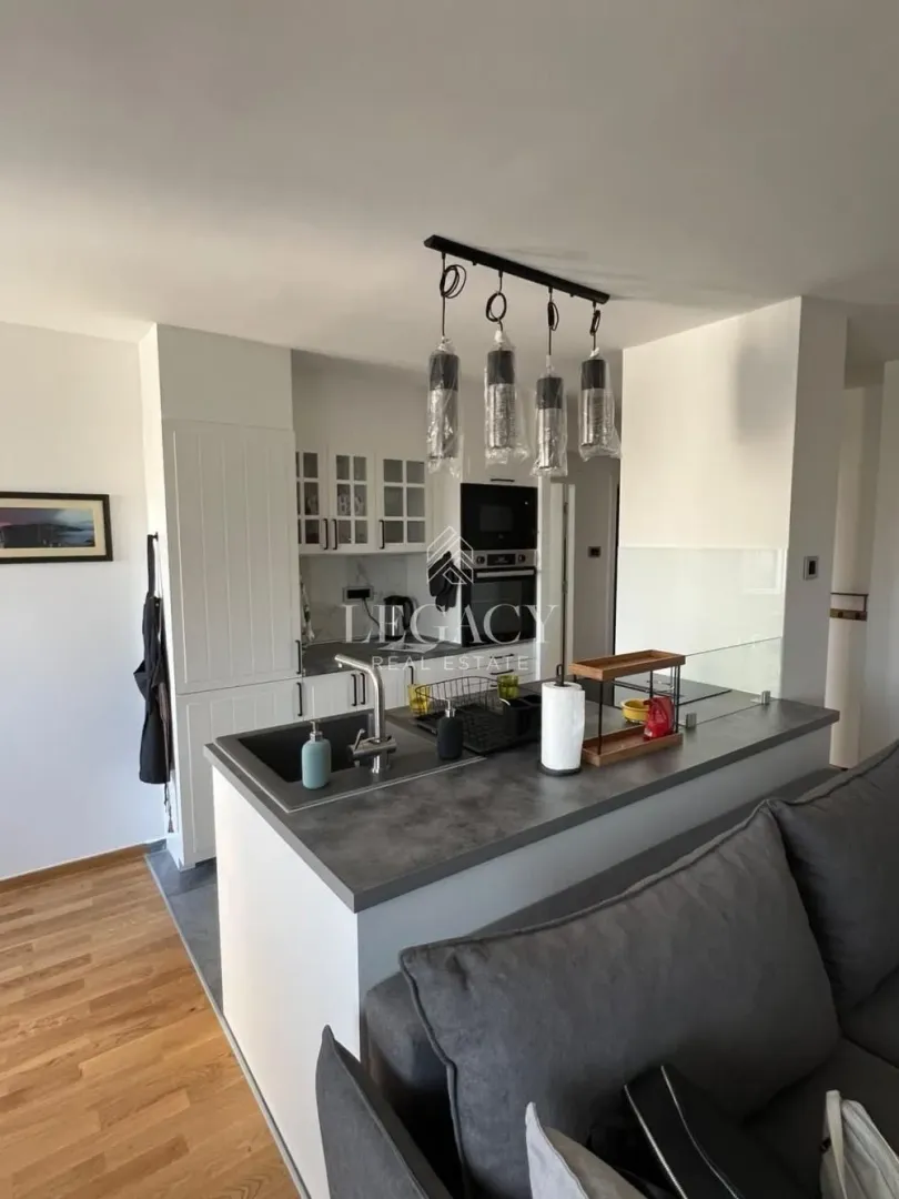 Modern kitchen with a bar counter and built-in appliances, open to the living room.