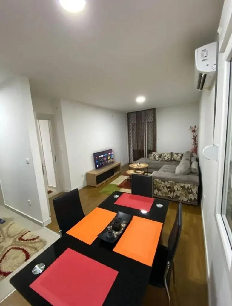 Living room with a sofa, TV, and dining table.