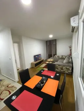 Living room with a sofa, TV, and dining table. - image 4