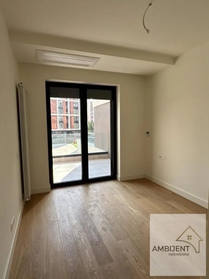Empty room with wooden flooring and access to the terrace.