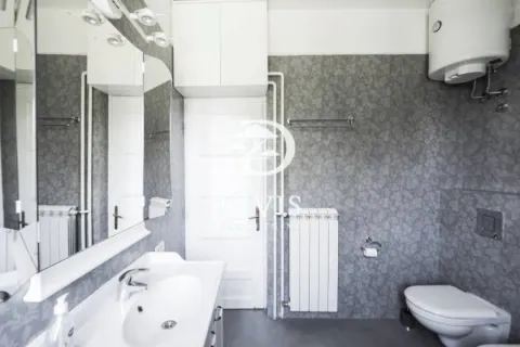 Bathroom with sink, mirror, toilet, and water heater. - image 18