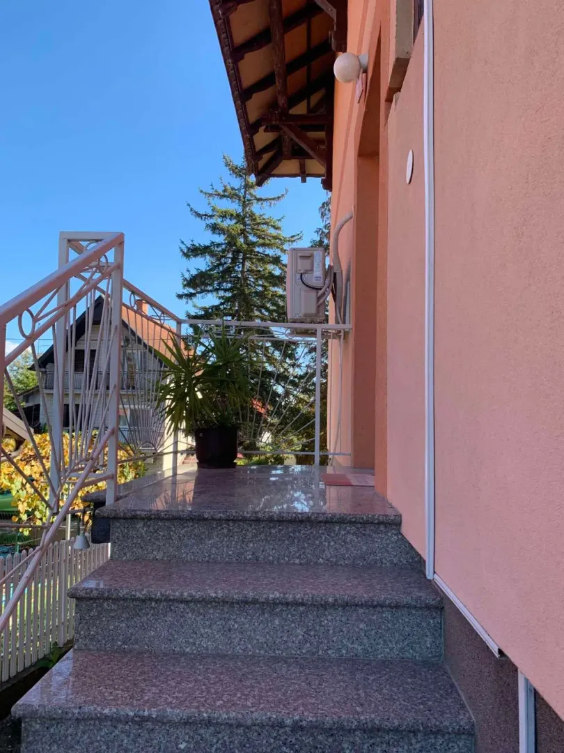 Entrance stairs and porch of the house with a railing.