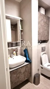 Smaller bathroom with a washbasin, mirror, and toilet. - image 9
