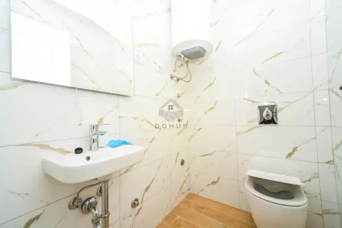 Manje kupatilo sa bijelim pločicama sa mermernim šarama, umivaonikom i wc šoljom. - image 7