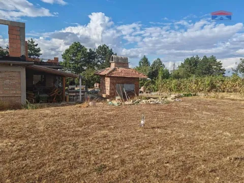 View of the yard and a house under construction with an outbuilding. - image 15