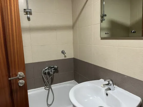 Simple bathroom featuring a bathtub, sink, and mirror. - image 4
