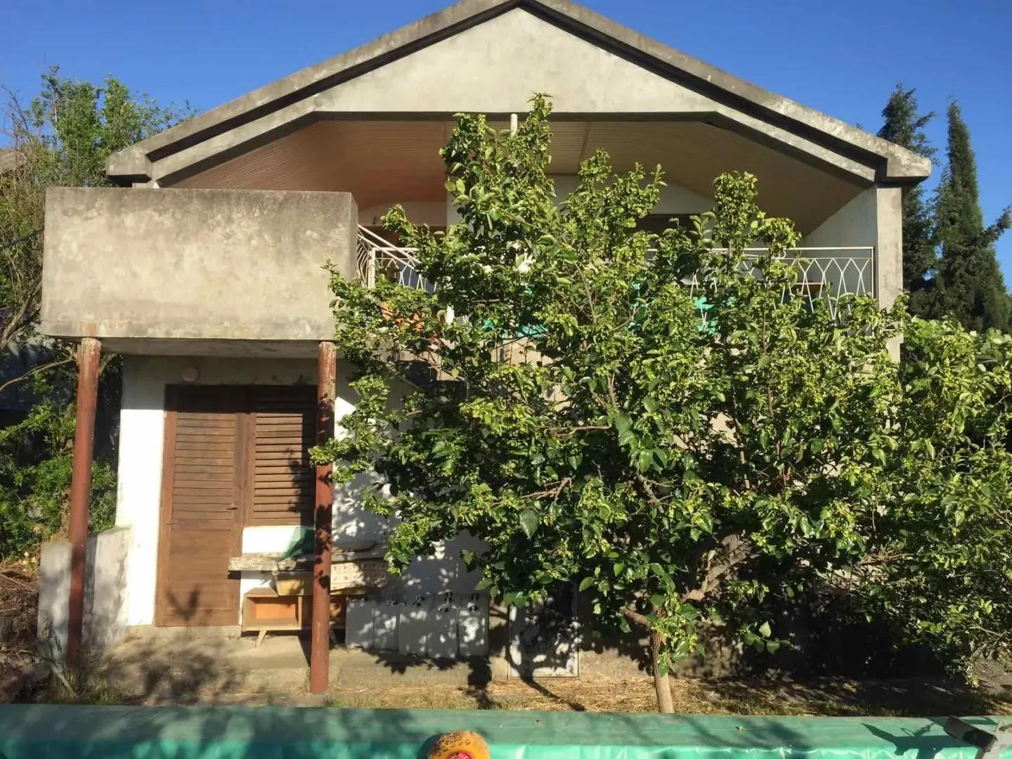 Exterior view of a two-story house with a yard and trees.