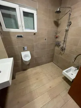 Kupatilo opremljeno tuš kabinom, umivaonikom i sanitarijama. - image 9