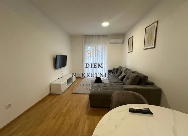 Living room with a sofa, TV, and dining table.