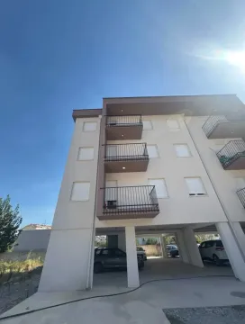 Exterior view of the apartment building with balconies and ground floor parking. - image 7