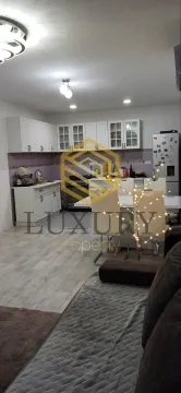 Open-plan living room with kitchen and dining area. - image 6