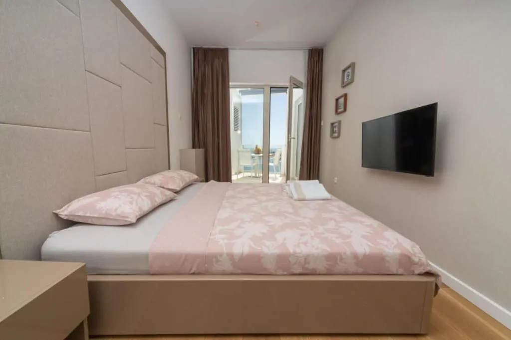 Furnished bedroom with a double bed, TV, and access to the terrace.