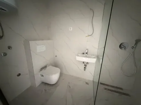 Novoopremljeno kupatilo sa tuš kabinom i bijelim sanitarijama. - image 9