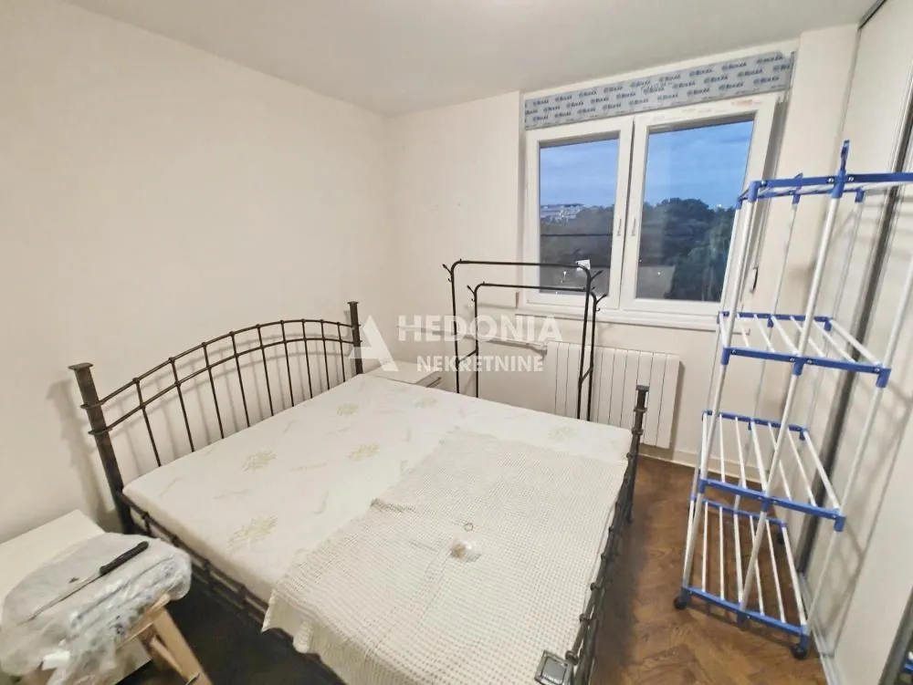 Spavaća soba sa bračnim krevetom i prozorom.