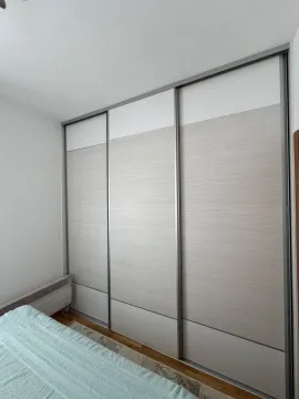 A bedroom with a large built-in wardrobe and a bed. - image 7