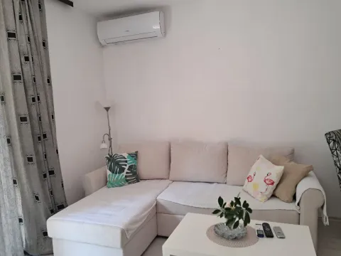 Living room with a sectional sofa and an air conditioner. - image 7