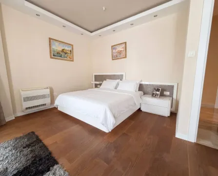 A furnished bedroom with a double bed and wooden flooring. - image 8