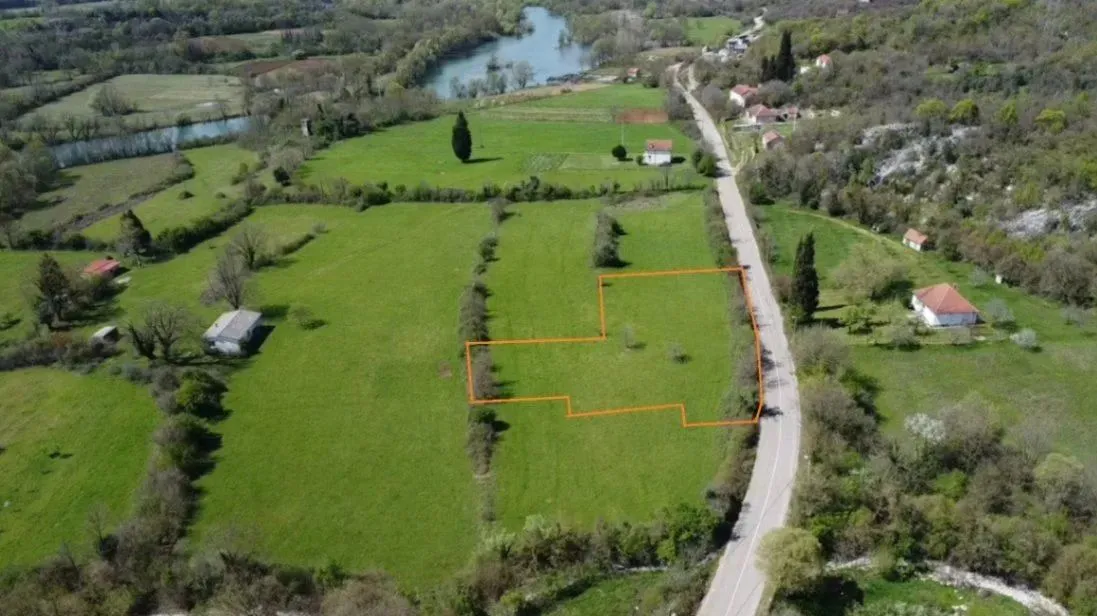 Pogled iz vazduha na zemljište sa ucrtanim granicama parcele pored puta.