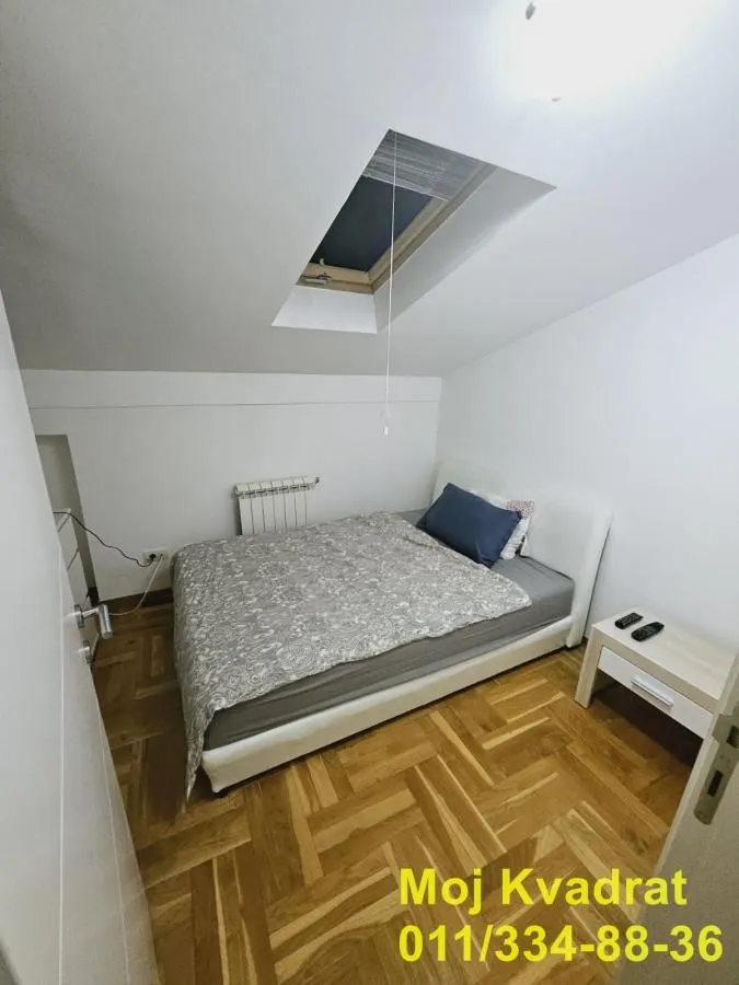 Spavaća soba sa bračnim krevetom i krovnim prozorom.