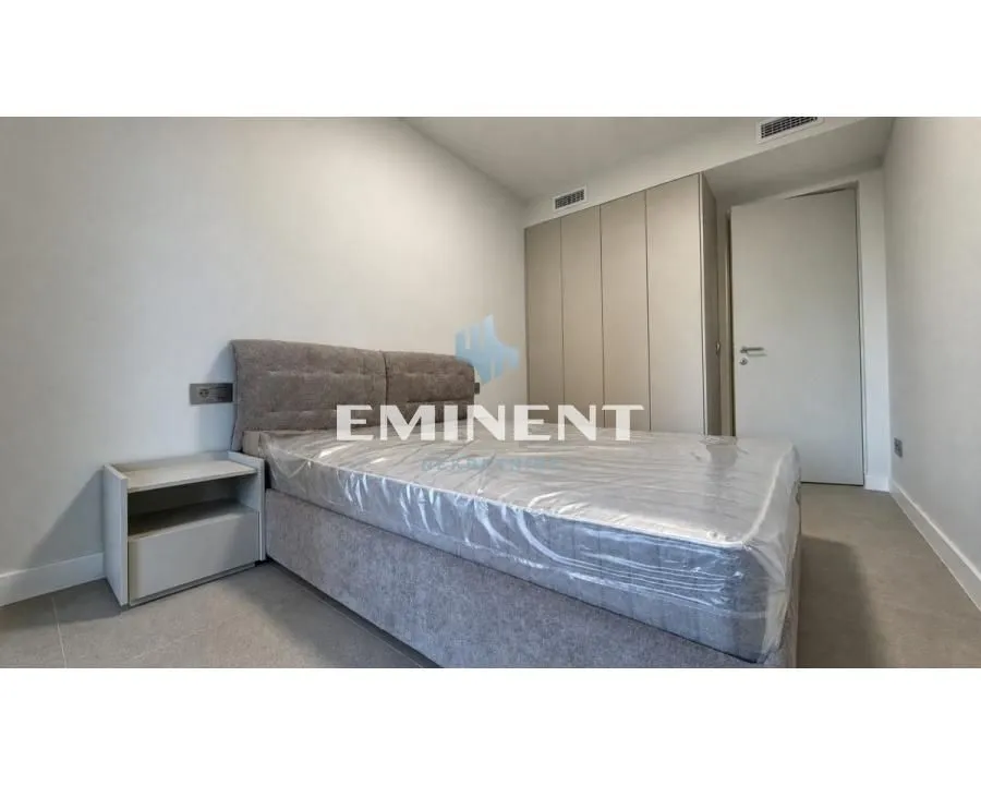 Modern bedroom with a double bed, nightstand, and fitted wardrobe.