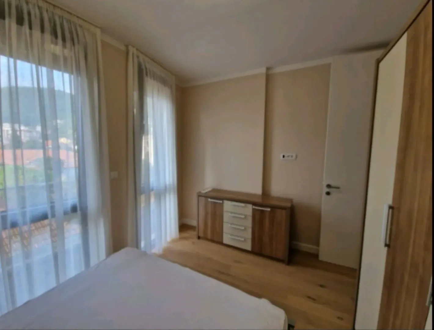 Namještena spavaća soba sa krevetom, garderoberom i komodom.