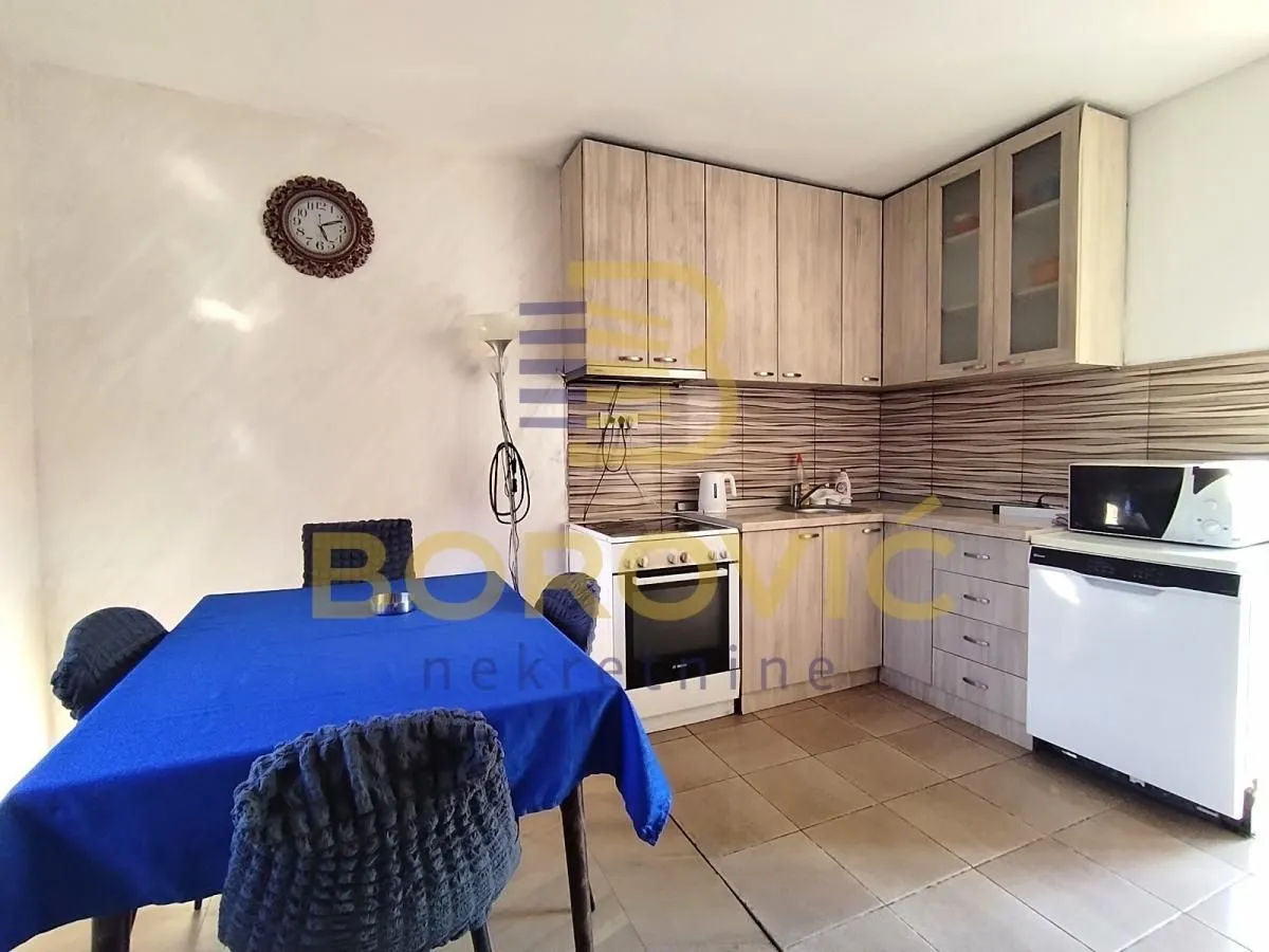Smaller kitchen with a dining table and wooden cabinets.