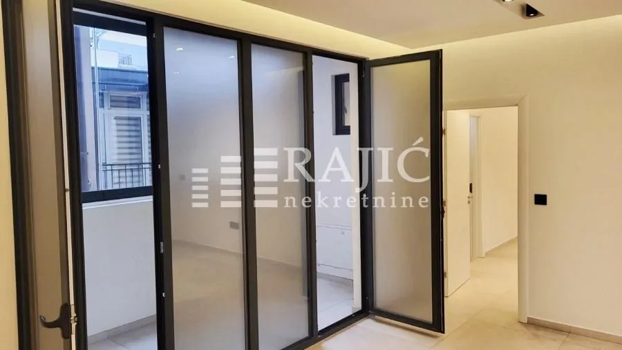 Living room with glass partition doors and access to the terrace.