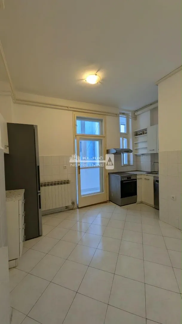 Kitchen with cabinetry, refrigerator, and access to the terrace.