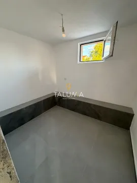 Empty room with white walls, grey floor tiles, and a window with an outside view. - image 6
