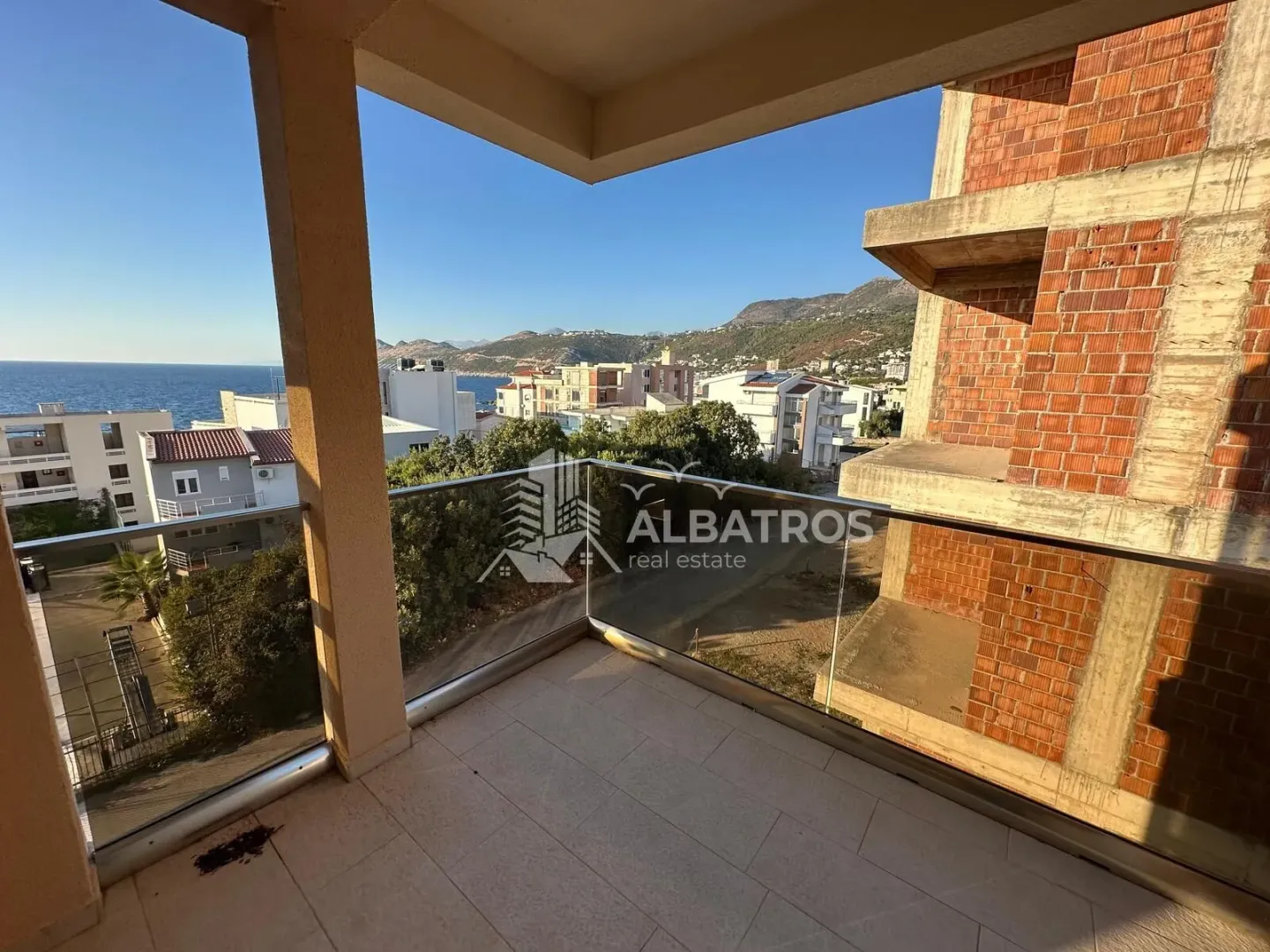 Natkriveni balkon sa staklenom ogradom i pogledom na more i okolinu.