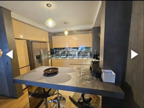 Modern kitchen with a breakfast bar and built-in appliances. - image 10