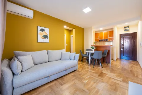Living room with a sofa and dining area in an open-plan space. - image 2