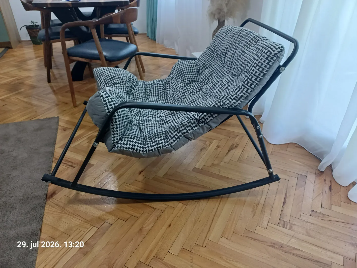 Dnevna soba sa foteljom na ljuljanje i trpezarijskim stolom u pozadini.