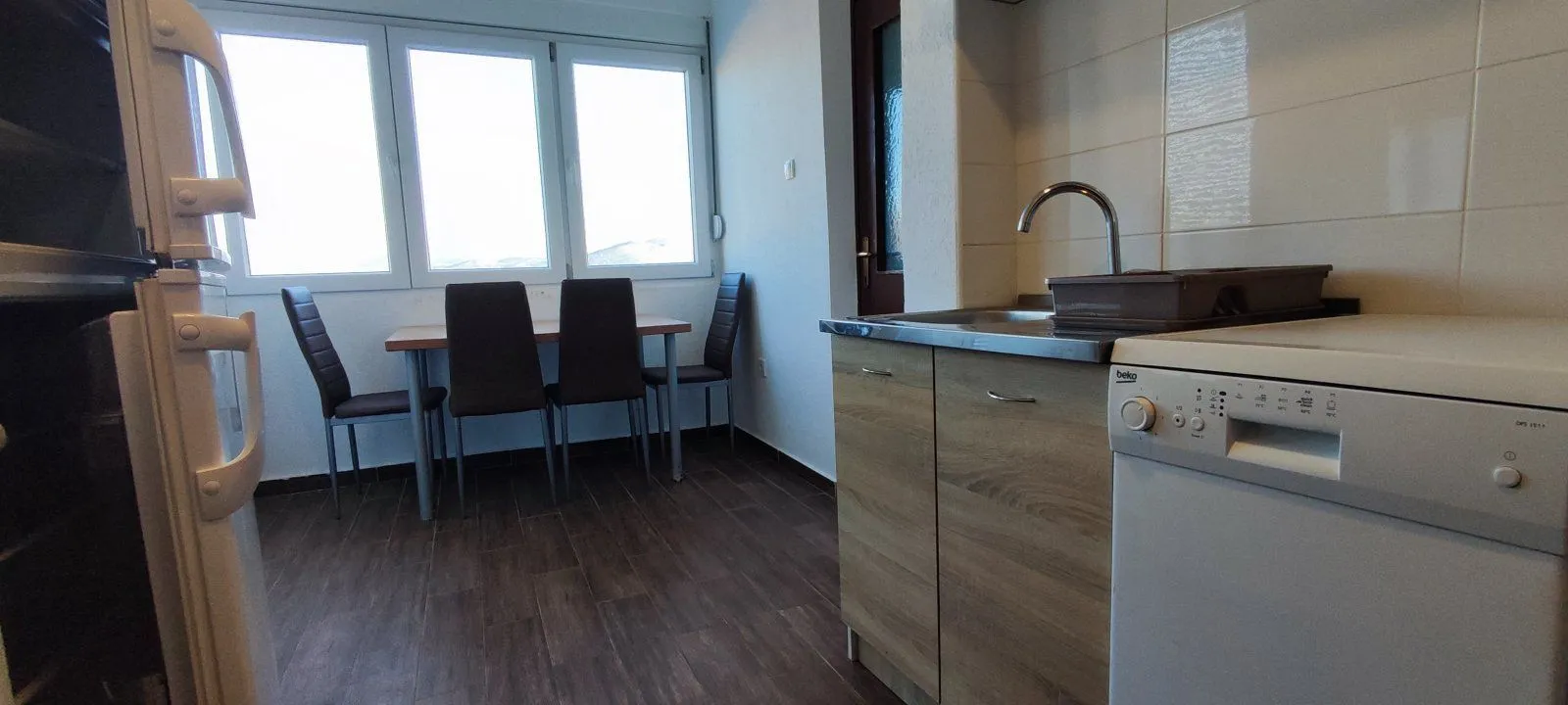 Kitchen with a dining table and chairs next to the window.
