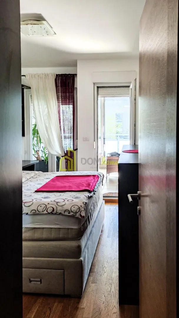 View from the hallway into the bedroom with a bed and access to the terrace.