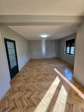 Empty room with parquet flooring and grey walls. - image 2
