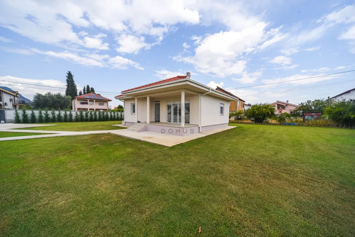 Exterior view of the house with a spacious yard and lawn.