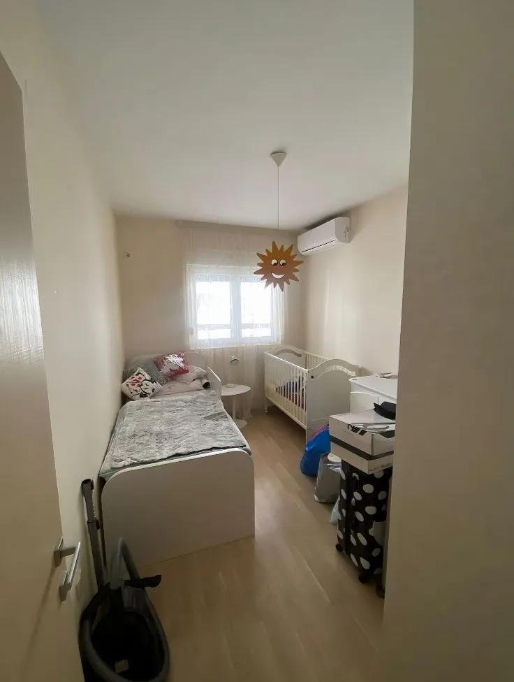 Children's bedroom with a bed and a baby crib.