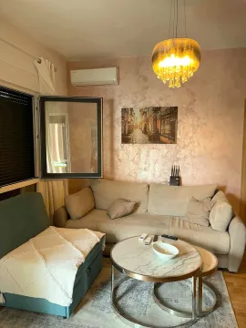 Living room with a sofa, coffee table, and lighting. - image 2