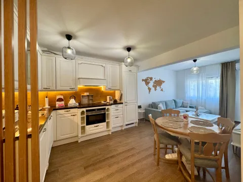 Modern white kitchen with a dining area and a view of the living room. - image 7