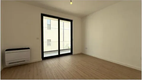 Empty unfurnished room with laminate flooring and balcony doors. - image 4