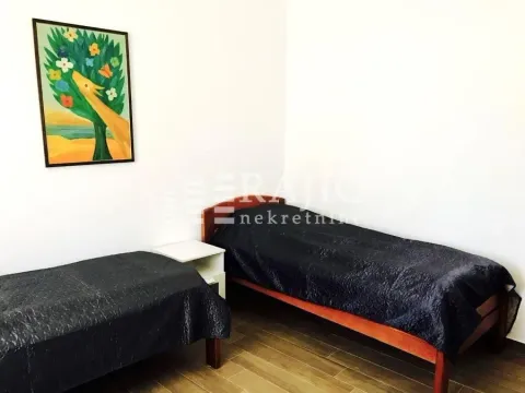 Bedroom with two beds and a painting on the wall. - image 8