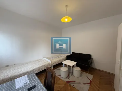 Living room with beds, couch, dining table and hardwood flooring. - image 5