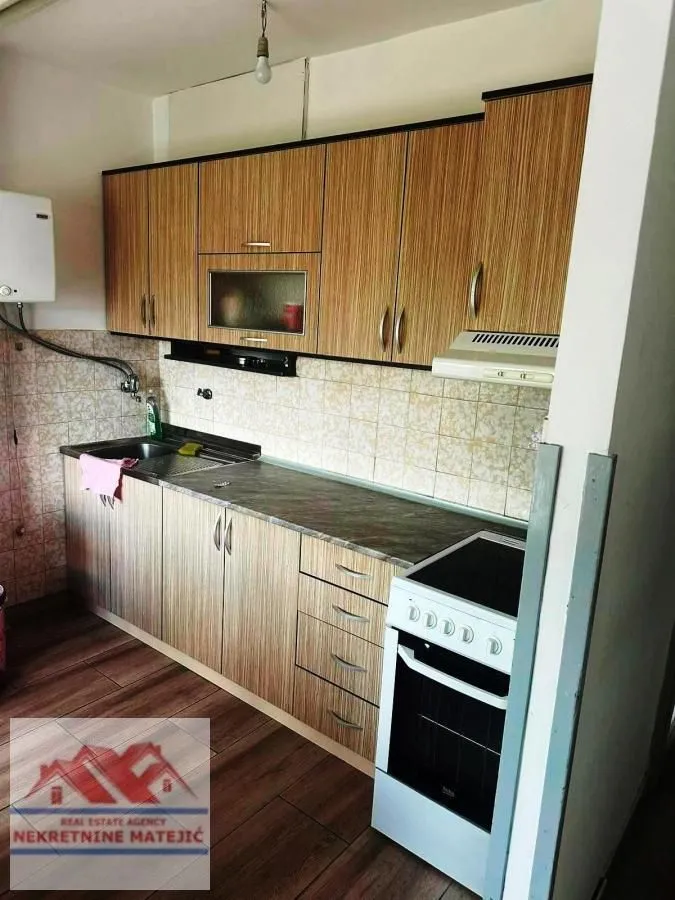 Small kitchen with wooden cabinetry and a white stove.