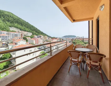 Covered balcony with patio furniture and a view of the town and sea. - image 3