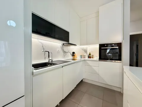 Moderna bijela kuhinja sa ugradnim aparatima i mermernim detaljima. - image 6