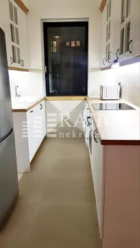 Modern white kitchen with built-in appliances and a window. - image 4