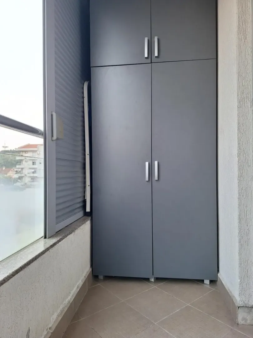 Glazed terrace with a grey wardrobe.